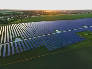 48mp Prints: Aerial drone view of large solar panels at a solar farm at bright summer sunset