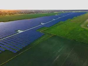 48mp Prints: Aerial drone view of large solar panels at a solar farm at bright summer sunset