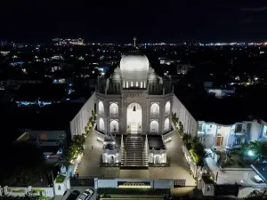 Masjid Prints: Aerial drone view of modern Masjid Ramlie Musofa at night in Jakarta Kemayoran with Jakarta cityscape