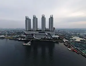 Aerial drone view of Muara Angke Beach with wooden boats leaning beside the pier