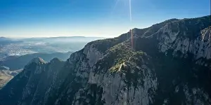 Aerial; drone view of multi-peaked mountain range near Barcelona; sunny winter cloudless day