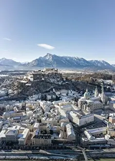 Salzach Prints: Aerial drone view of snowy Hohensalzburg fortress with view of Unesberg mountain in winter morning