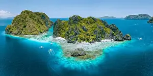 Hopping Prints: Aerial drone view of tropical Shimizu Island steep rocks and white sand beach in blue water El Nido