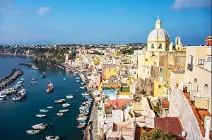 Aerial drone view of vibrantly colorful houses of Marina Corricella in sunny summer weather at Procida island, Italy