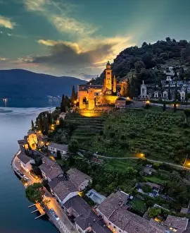 Lago Prints: Aerial image of the parish church Madonna del Sasso stands on the high hill of Vico Morcote at sunset