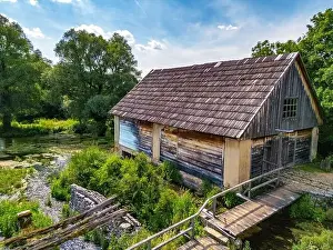 Drone Perspective Prints: Aerial image of Wonderful Majerovo Vrilo wooden houses and Gacka river source in the village of Sinac