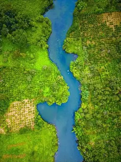 Aerial landscape of winding clear blue river in green field