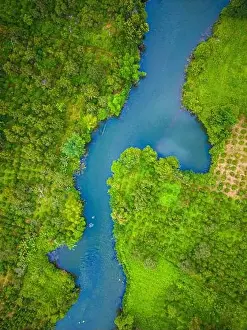 Aerial landscape of winding clear blue river in green field