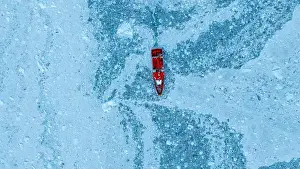 Shipwreck Prints: Aerial of a little ship floating between the ice below the Eqi glacier