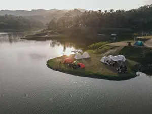 Aerial morning view of camping ground area by the Sermo Lake with forest hill on the background in Kulonprogo
