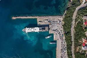 Cephalonia Prints: Aerial overhead drone shot of cars embarking on big cruise ship at Poros town harbour of Kefalonia Island