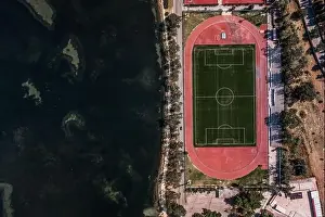 Cephalonia Prints: Aerial overhead drone shot of football field by Ionian sea in Argostolion