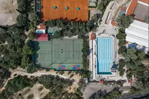 Gods View Prints: Aerial overhead drone shot of hard and clay tennis court besides swimming pool in Athens