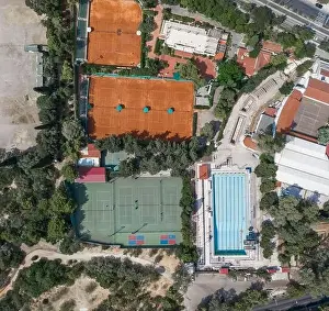 Gods View Prints: Aerial overhead drone shot of hard and clay tennis court besides swimming pool in Athens