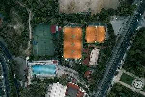Gods View Prints: Aerial overhead drone shot of tennis court with lights and swimming pool at dusk in Athens