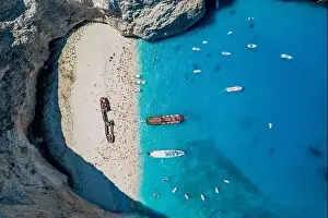Noon Prints: Aerial overhead drone shot of Zakynthos Navagio beach with tourists