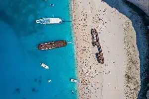 Noon Prints: Aerial overhead drone shot of Zakynthos Navagio beach full of tourists and cruise ship in Ionian sea in Greece