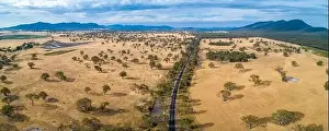 Agricultural Land Prints: Aerial panorama of Australian outback and rural road with mountains