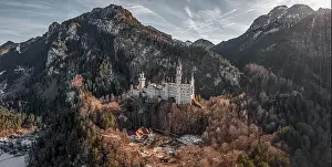 Fussen Prints: Aerial panorama drone shot of picturesque Neuschwanstein Castle on snowy hill in winter sunlight in Germany