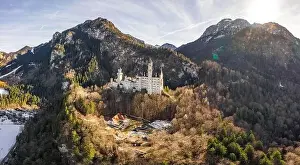 Fussen Prints: Aerial panorama drone shot of picturesque Neuschwanstein Castle on snowy hill in winter sunlight in Germany