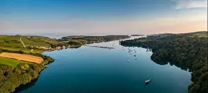 Castletownshend Prints: An aerial panorama landscape in warm evening light over Castlehaven Bay with many sailboats anchored