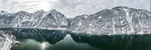 Northern Limestone Alps Prints: Aerial panoramic drone shot of Hallstatt village by lake surrounded by snow covered mountain in overcast winter time