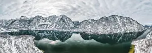 Northern Limestone Alps Prints: Aerial panoramic drone shot of Hallstatt village by lake surrounded by snow mountains with couds during winter