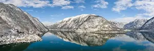 Northern Limestone Alps Prints: Aerial panoramic drone shot of snow mountains by Halstatt lake and village in snow under blue cear sky during winter