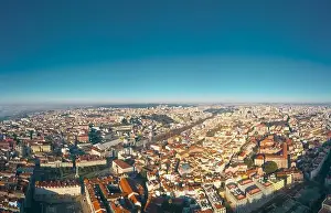 Separated Prints: Aerial; panoramic drone view of foggy Lisbon morning; impending clouds over the ancient ginger roofs; blue skyline