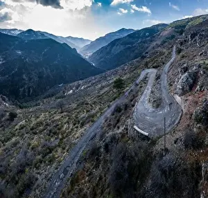 Aerial panoramic drone view of a scenic highway by the beautiful Landscape covered in clouds and fog
