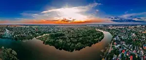 Aerial panoramic view of of small european city placed on river banks at summer sunny day with clouds