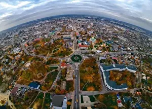 Aerial panoramic view of roundabout road with circular cars in small european city at cloudy autumn day