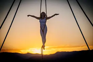 Ascension Prints: Aerial performer suspended on silks with a sunset backdrop over mountains. WA, USA