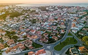 An aerial perspective captures the warm glow of sunset over the picturesque coastal town of Cascais, Portugal