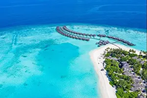 Aerial photo of beautiful Maldives paradise tropical beach. Amazing view, blue turquoise lagoon water, palm trees and white sandy beach. Luxury travel