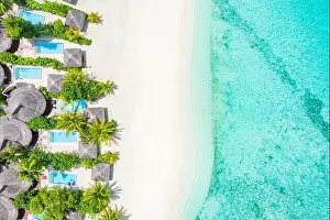 Aerial photo of beautiful Maldives paradise tropical beach. Amazing view, blue turquoise lagoon water, palm trees and white sandy beach. Luxury travel