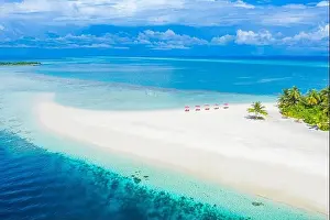 Aerial photo of beautiful Maldives paradise tropical beach. Amazing view, blue turquoise lagoon water, palm trees and white sandy beach. Luxury travel