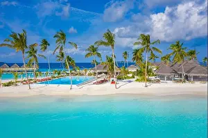 Aerial photo of beautiful Maldives paradise tropical beach. Amazing view, blue turquoise lagoon water, palm trees and white sandy beach. Luxury travel
