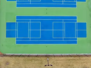 Extended Prints: Aerial photo of unusually painted outdoor blue tennis courts with yellow pickleball lines and green out of bounds area