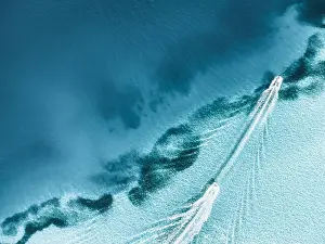 Birds Eye Prints: An aerial top shot of a boat leaving trail on clear seawater