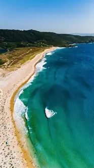 Aerial shot capturing a vibrant beach scene along the coast of Galicia