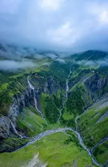 Aerial shot of several large waterfalls cascading down a steep cliff