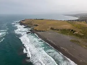 Surfers Prints: Aerial shot of the pacific ocean, beach and the bay La Pancora at Pichilemu, Chile