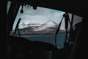 Koltur Prints: Aerial shot of snow-covered Faroese mountains taken from the inside of a helicopter during a flight over the Faroe