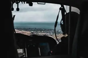 Explore Denmark Prints: Aerial shot of the snow-covered town Torshavn taken from the inside of a helicopter during a flight over the Faroe