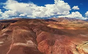 Aerial shot of the textured yellow nad red mountains resembling the surface of Mars