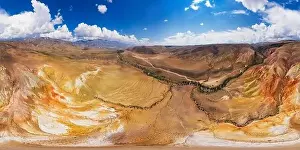 Aerial shot of the textured yellow nad red mountains resembling the surface of Mars