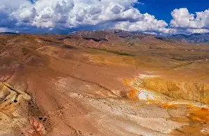 Aerial shot of the textured yellow nad red mountains resembling the surface of Mars