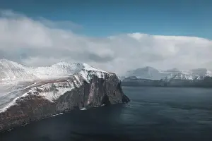 Explore Denmark Prints: Aerial shot of Trollkonufingur from a helicopter with view of snow-covered peaks
