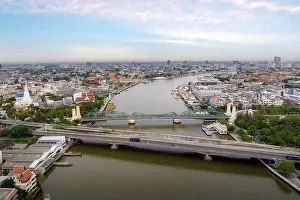 Aerial shots taken from a drone of Phra Pok Klao Bridge and Phra Phuttha Yot Fa Bridge. crossing the Chao Phraya River in the morning with temple